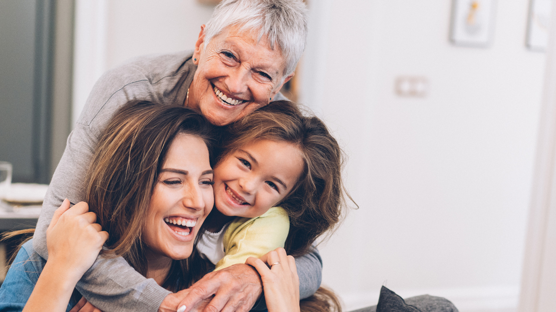 Three generations of women hugging each other.