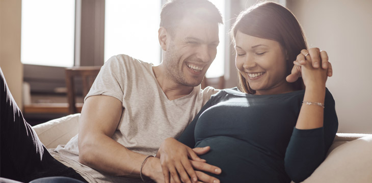 一个男人把手放在孕妇的肚子上。