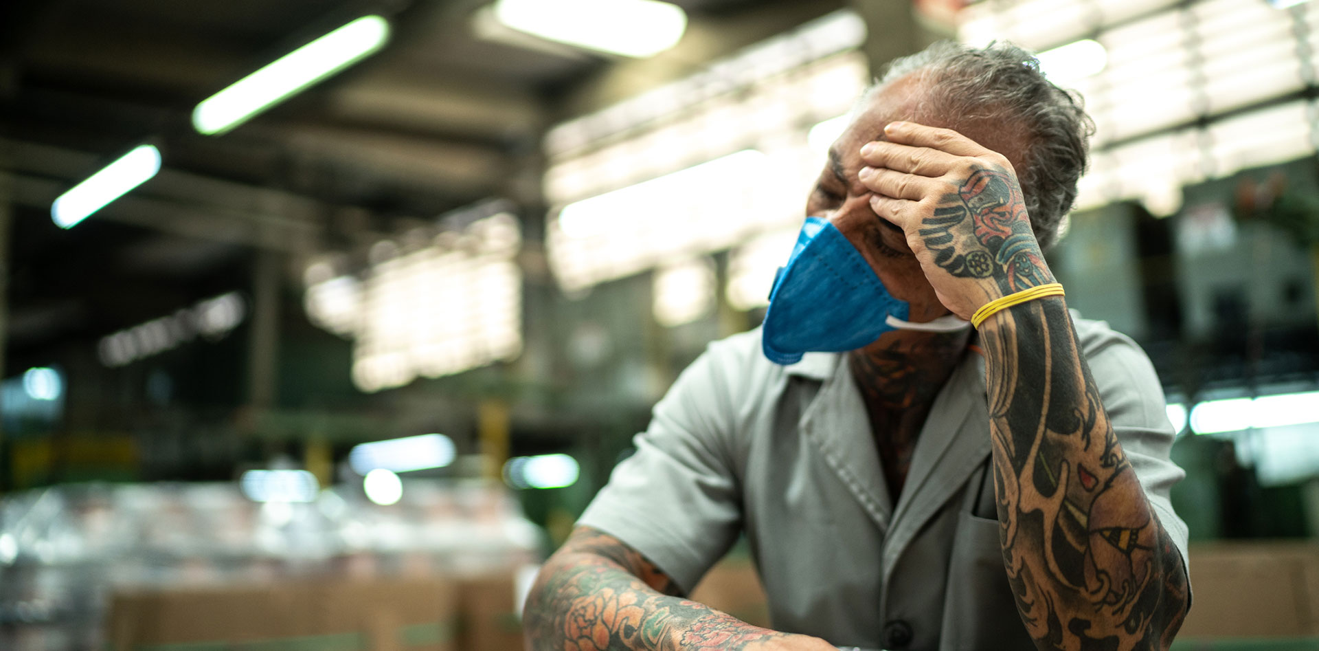 Exhausted man with his head in his hand.