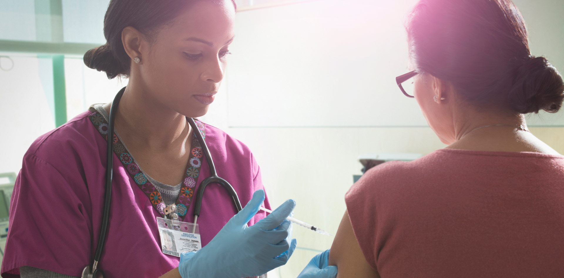 Female nurse administering injectable medication into a female patient
